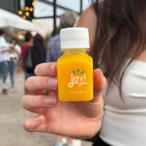 A hand holding a 2oz Citrus Punch bottle of Jovi Juice
